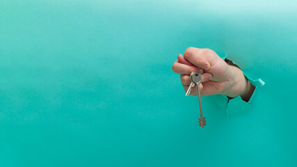 The man holds the keys to the apartment in his hand and shows the gesture of contempt sign from his...