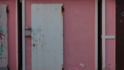 A white wooden door of a pink beach hut (Pesaro, Italy, Europe)