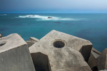 An arrow shaped concrete retainer structure in the foreground and the ocean in the background, Lambert's Bay, Western Cape, South Africa.