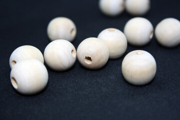 Wooden beads on a black background. Craft.