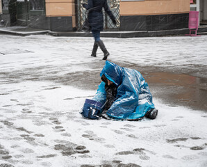 Poor old woman begging for alms on the street of the city