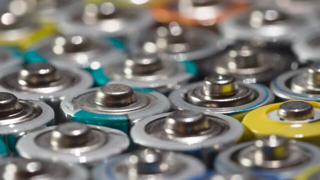 Old Battery Conveyor. Loop. Dense array of AA batteries moving with slight rotation close-up