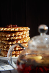 tea ceremony, waffle cookies in the background, on a fabric background and dark background.