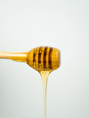 Honey dripping from a wooden spoon