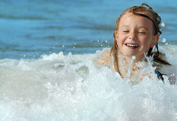 Smiling cute girl playing in the sea