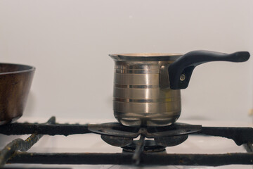 Obraz premium Hot coffee prepared in turk on a gas retro stove