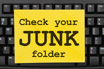 Check your junk folder message on a black keyboard