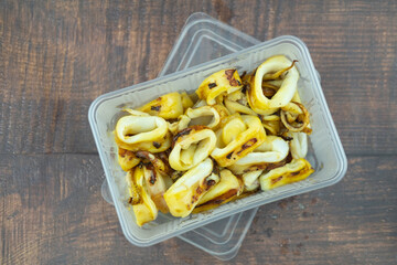 Slice of delicious grilled squid in plastic box, Thai style food. Concept of take away