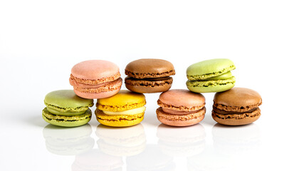 French dessert for coffee. alined multicolored macarons on white background