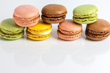 French dessert for coffee. Close up alined multicolored macarons on white background