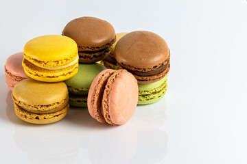 Close-up of French dessert for coffee. Multicolored macarons on white background