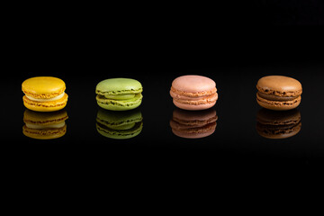 Multicolored macarons on a black background