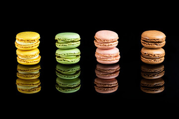 Multicolored macarons lined up on a black background