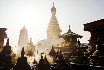 Swayambhunath stupa in Kathmandu, Nepal. Backlit smoke in the morning light. - obrazy, fototapety, plakaty