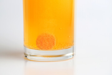 Orange effervescent tablet dissolving in water