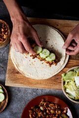 young man filling a durum or a burrito