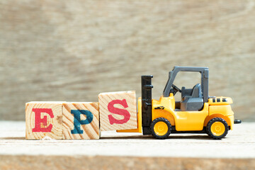 Toy forklift hold letter block S to complete word EPS (Abbreviation of Earnings per share) on wood background