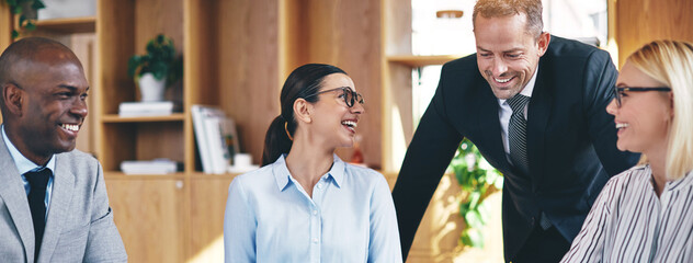 Diverse businesspeople laughing during a meeting in an office
