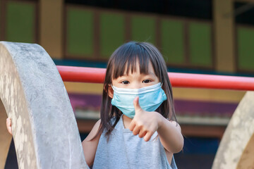 Portrait image of 2-3 yeas old baby. Happy Asian child girl smiling and wearing fabric mask,​ She...