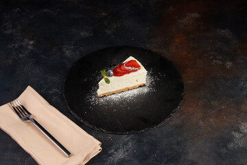 Cheesecake with strawberries, dark background