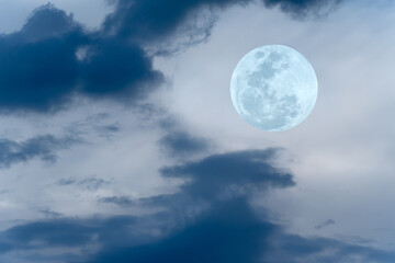 Fototapeta na wymiar Full moon with blurred clouds on the sky.