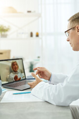 Doctor talking with patient through video call in clinic