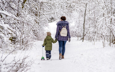 A woman with her son walking in a winter Park
