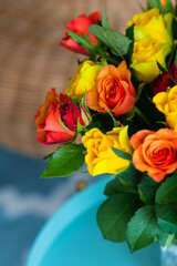 A bouquet with a lot of red orange and yellow roses on a table interior photography