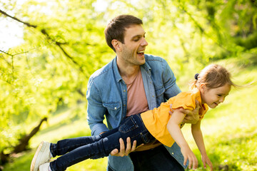 Single father having fun in the park with his cute little daughter