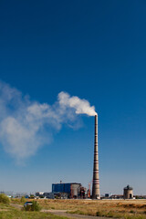 Fototapeta na wymiar Ekibastuz, Kazakhstan. The highest electric power plant chimney in the world. White steam pollution. blue sky.