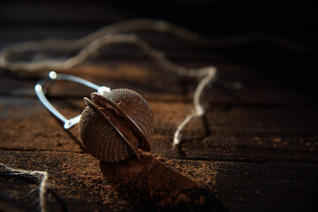 crumbly cocoa in a metal clip, on dark wood