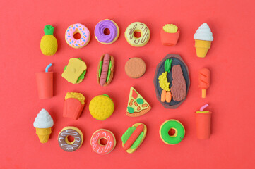 Selective focus of rubber food toys over red background.