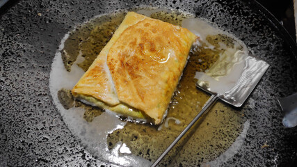 Martabak Telor or Martabak Telur fried on frying pan. Savory pan-fried pastry stuffed with egg, meat and spices. Martabak Telur is one of Indonesia street food