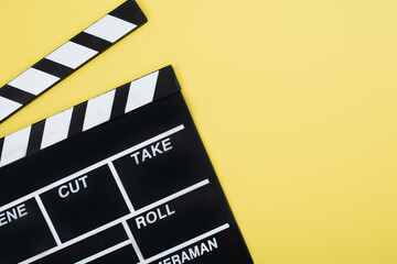 Fototapeta na wymiar top view of clapperboard on yellow background with copy space, cinema concept