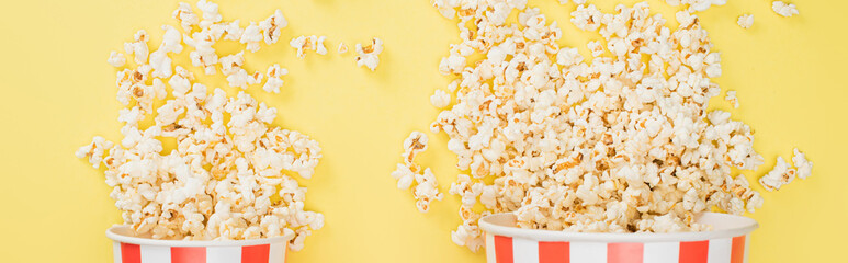 top view of big and small buckets with crunchy popcorn on yellow, banner, cinema concept