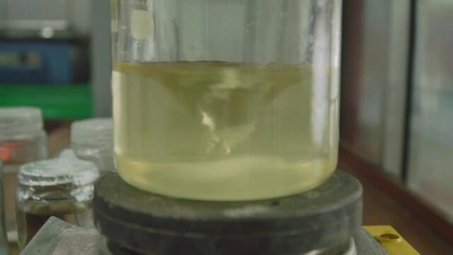 Yellow water Swirl in Lab glass beaker in chemical laboratory