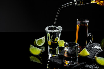 Mexican tequila with lime and salt on rustic black background. space for text. concept luxury...