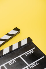 Fototapeta na wymiar close up view of clapperboard on yellow, cinema concept
