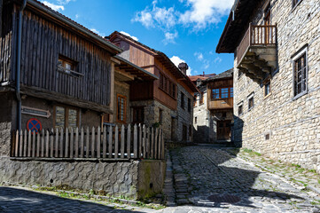 Fototapeta na wymiar Stone houses of traditional architecture and cobble-stone narrow street in the town of Metsovo, Greece