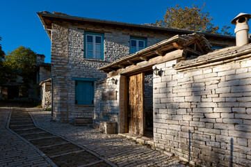 Stone houses of traditional architecture and cobble-stone narrow street in Papigo in Epirus, Greece