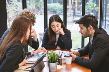 Business professional people group, team of young asian,caucasian working and communicating, analyzing data,discussing, using touchpad,tablet to explain about new project with colleagues in workplace.
