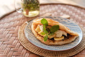 Crispy roti with banana and chocolate cream, sweet meal for enjoy eating on wooden table