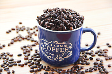 natural black coffee beans in a blue mug