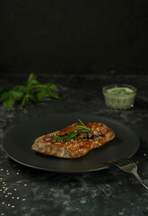 meat steak with green sauce on a dark background