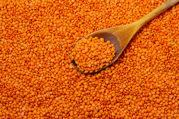 Red lentils on a white background. Lentil variety. Nutritious protein food. Wooden spoon with lentils