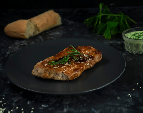 Meat Steak With Green Sauce On A Dark Background