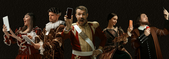 Modern tech devices. Medieval people as a royalty persons in vintage clothing on dark background....
