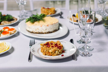 Wedding table with treats, beautiful setting. In the foreground, a meat salad with pomegranate seeds.