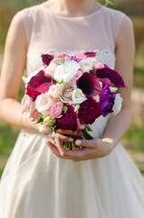 The bride holds a bouquet of flowers in her hands at the wedding, ceremony. Close-up.