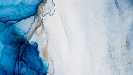 Blaue Alkoholflecken mit Zusatz von Goldpulver. Subtile Farbwellen, abstrakte blaue Wellen des Ozeans, Linien aus Marmor. Flüssigfarben, Verlaufsflecken, Malen. © MiaStendal